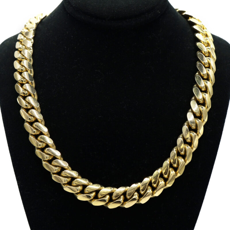 Heavy 14K yellow gold Cuban link chain necklace on a black display stand.