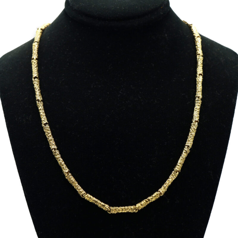 Heavy 18K yellow gold chain necklace with a nugget textured link design on a black display.