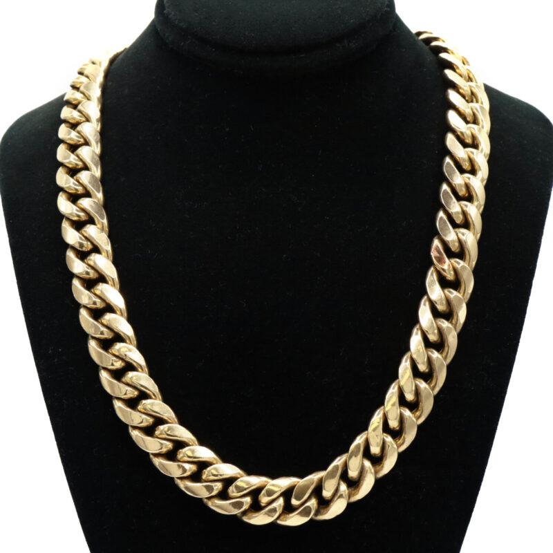 Cuban link 10K yellow gold chain necklace on a black display. Men's unisex jewelry.
