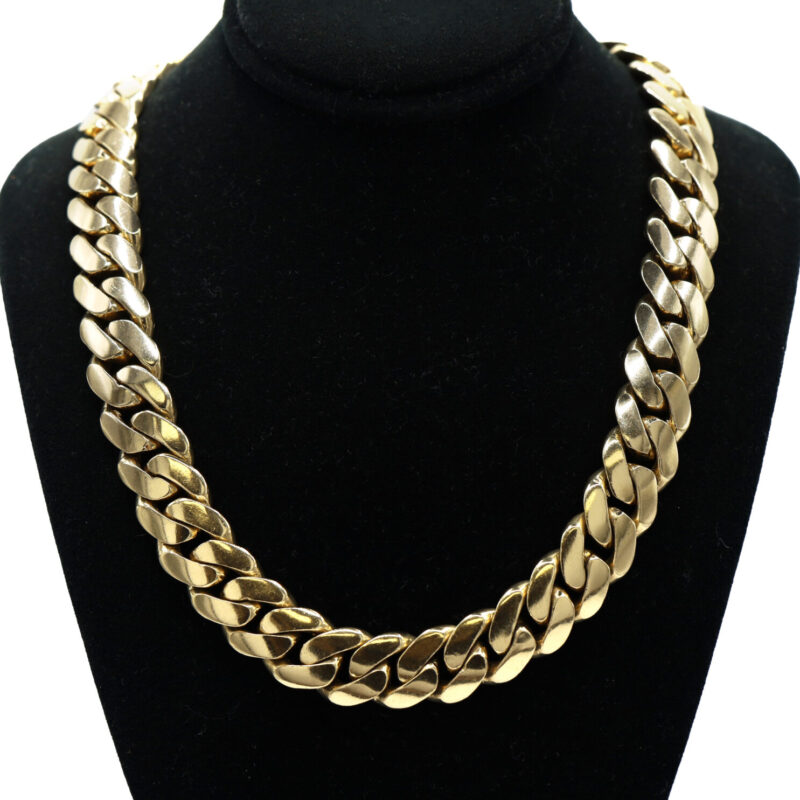 Heavy 14K yellow gold Cuban link chain necklace on a black jewelry display.
