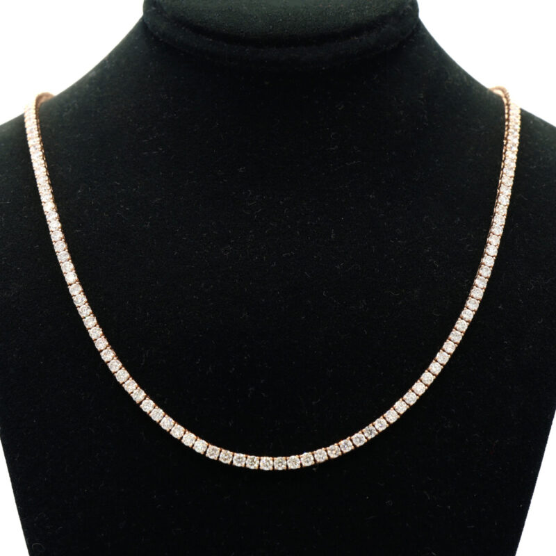 Rose gold tennis necklace with natural diamonds on a black jewelry display.
