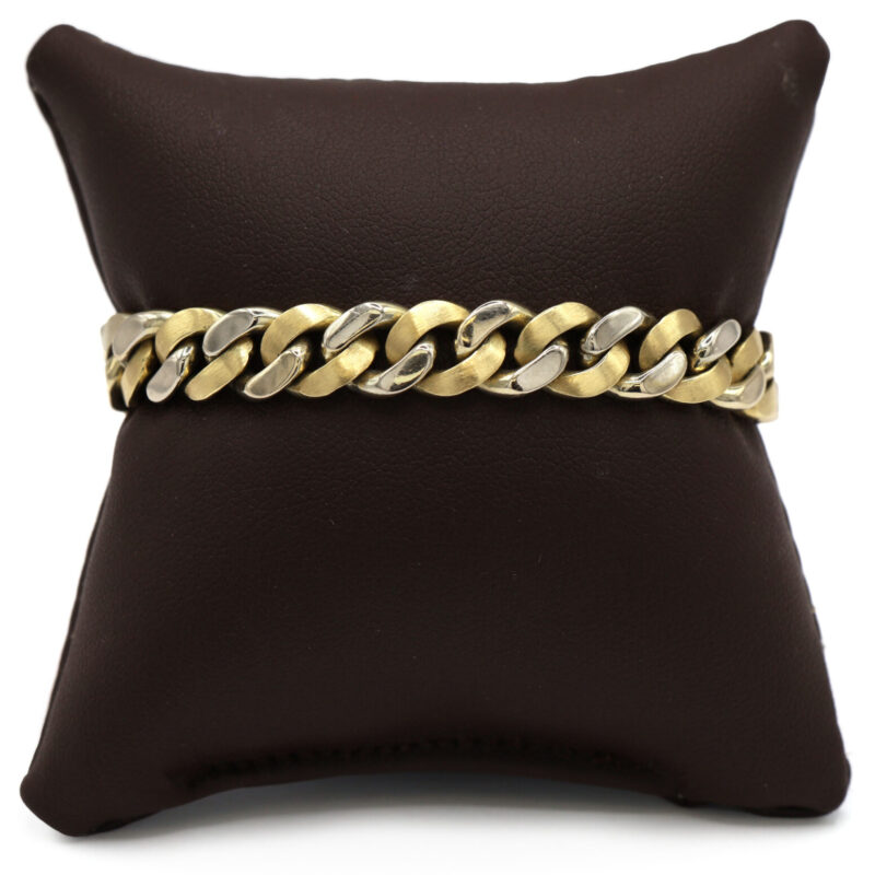 Two tone 14K yellow and white gold solid Cuban link bracelet on a brown display pillow.