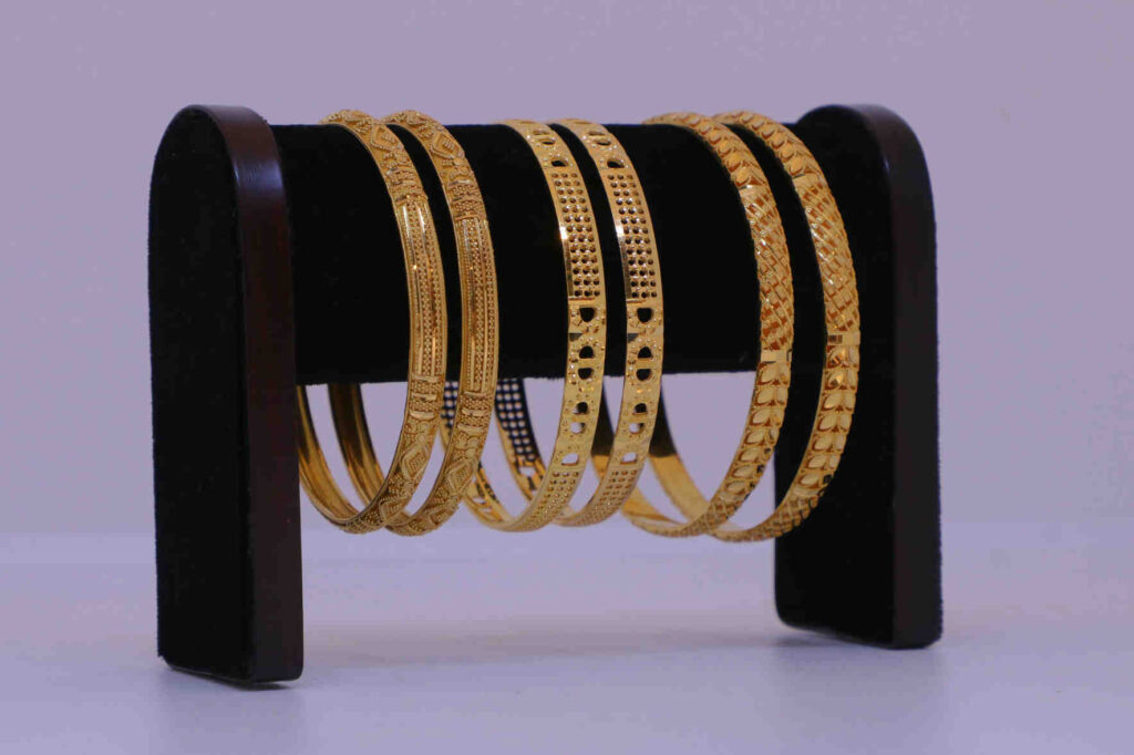 Jewelry trade-in gold bangles displayed on a stand ready for appraisal.