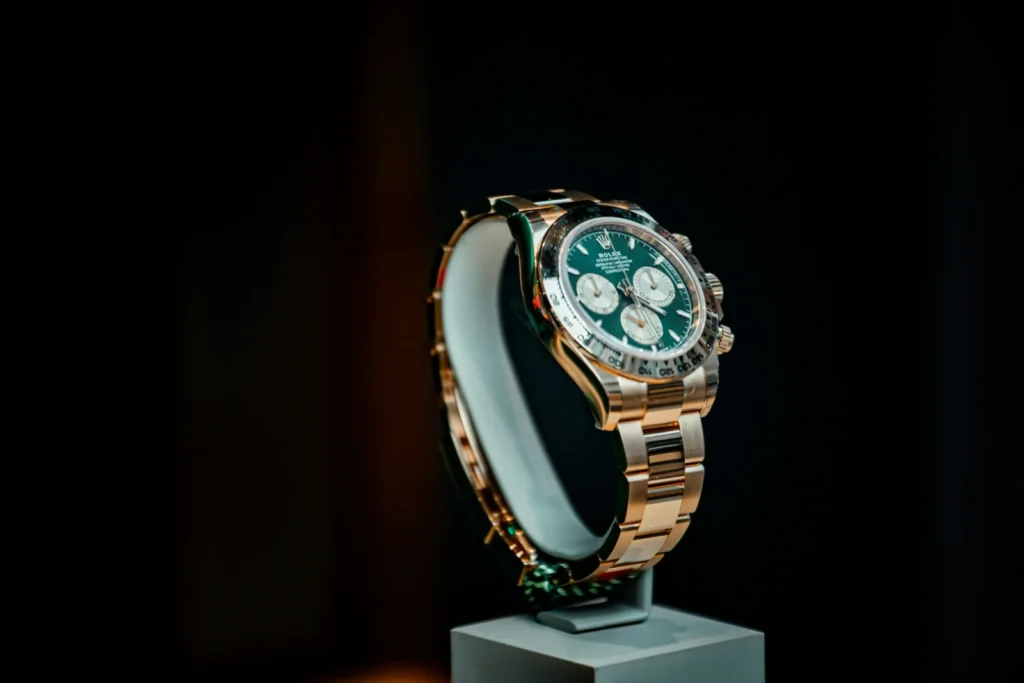 Luxury watch and jewelry display featuring a gold chronograph watch